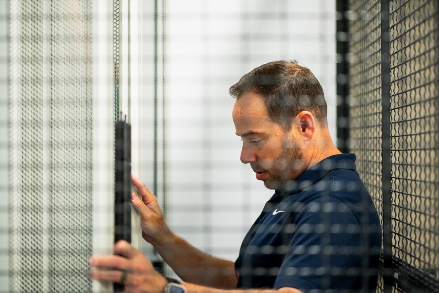 Technician working on network equipment behind the secure cage